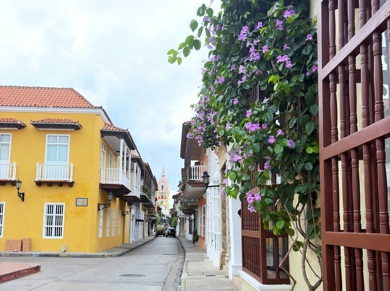 A colorful colonial street with flowering vines in Cartagena, Colombia.