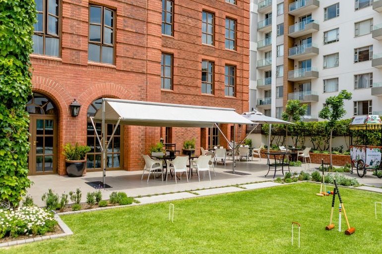 The garden terrace beside the red-brick facade of 54 on Bath in Johannesburg.