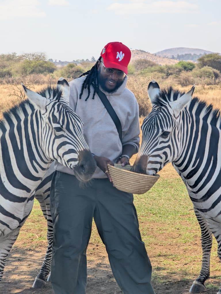 Nick feeding two zebras