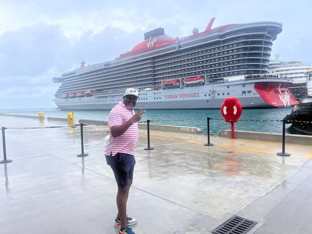 Norman Williams on the pier beside the Virgin Voyages ship Valiant Lady